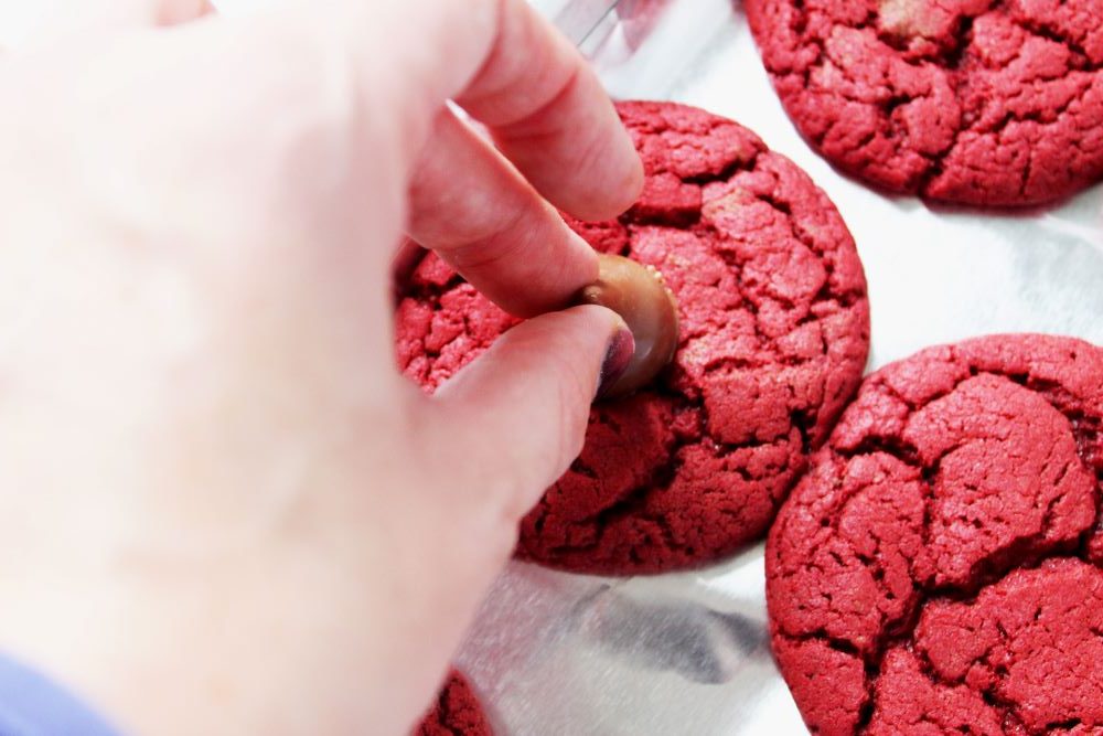 placing cherry kisses on red velvet cookies 1
