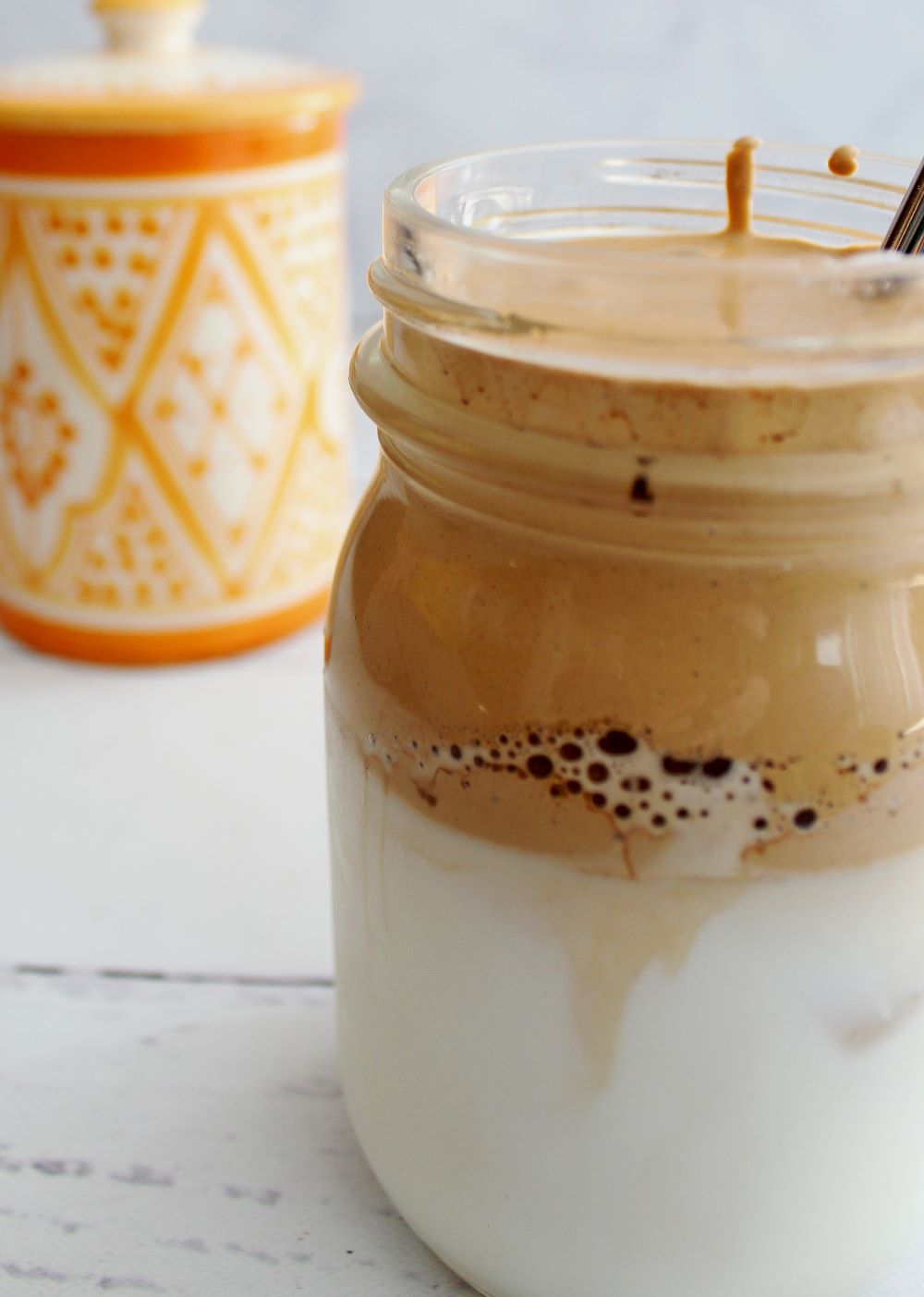 closeup mocha dalgona coffee with milk and globein sugar bowl in background 1