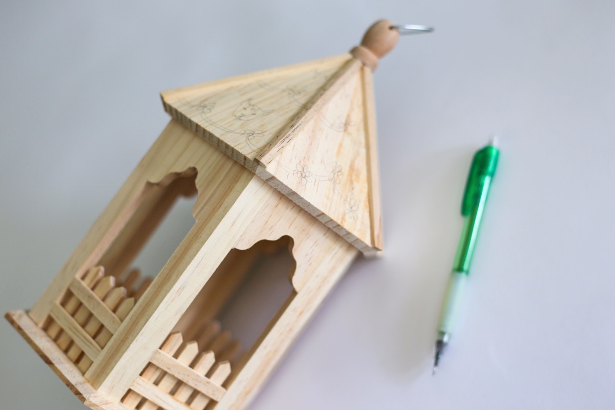 pencil the sides of the wooden birdhouse to paint it