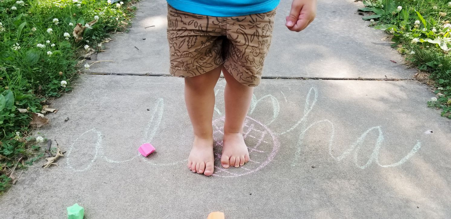 kids feet standing on chalk drawing 1