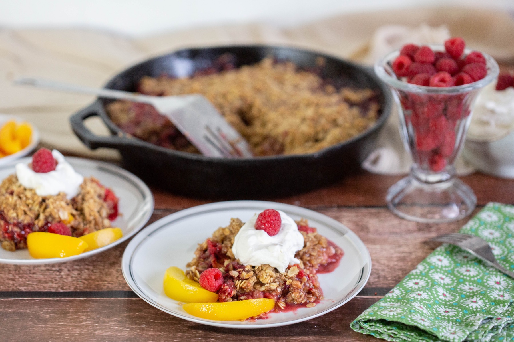 serve the peach crumble with whipped cream and raspberries