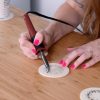 hand-using-wood-burning-tool-on-wood-coasters_square