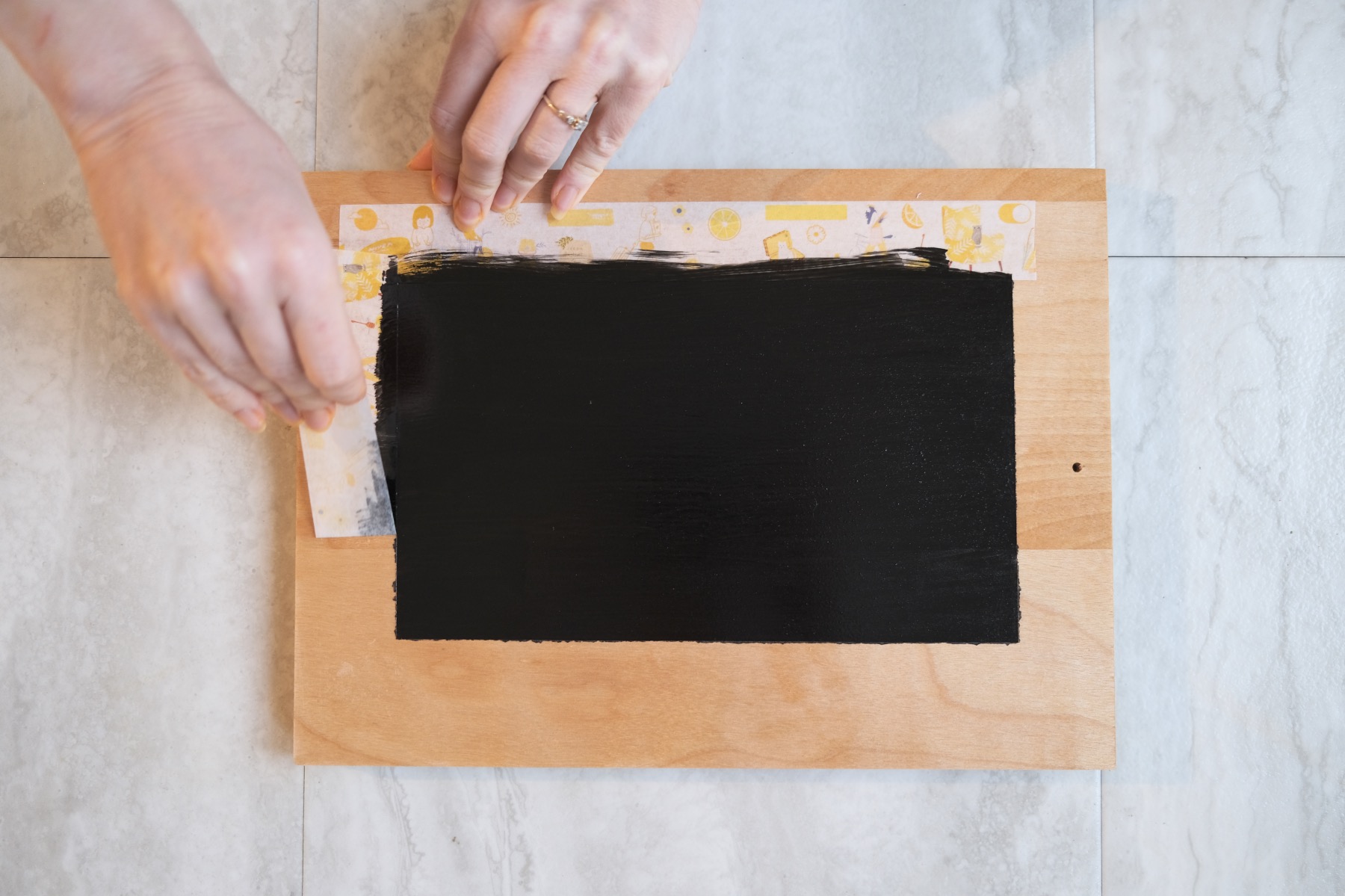 removing washi tape to reveal chalkboard painted tray