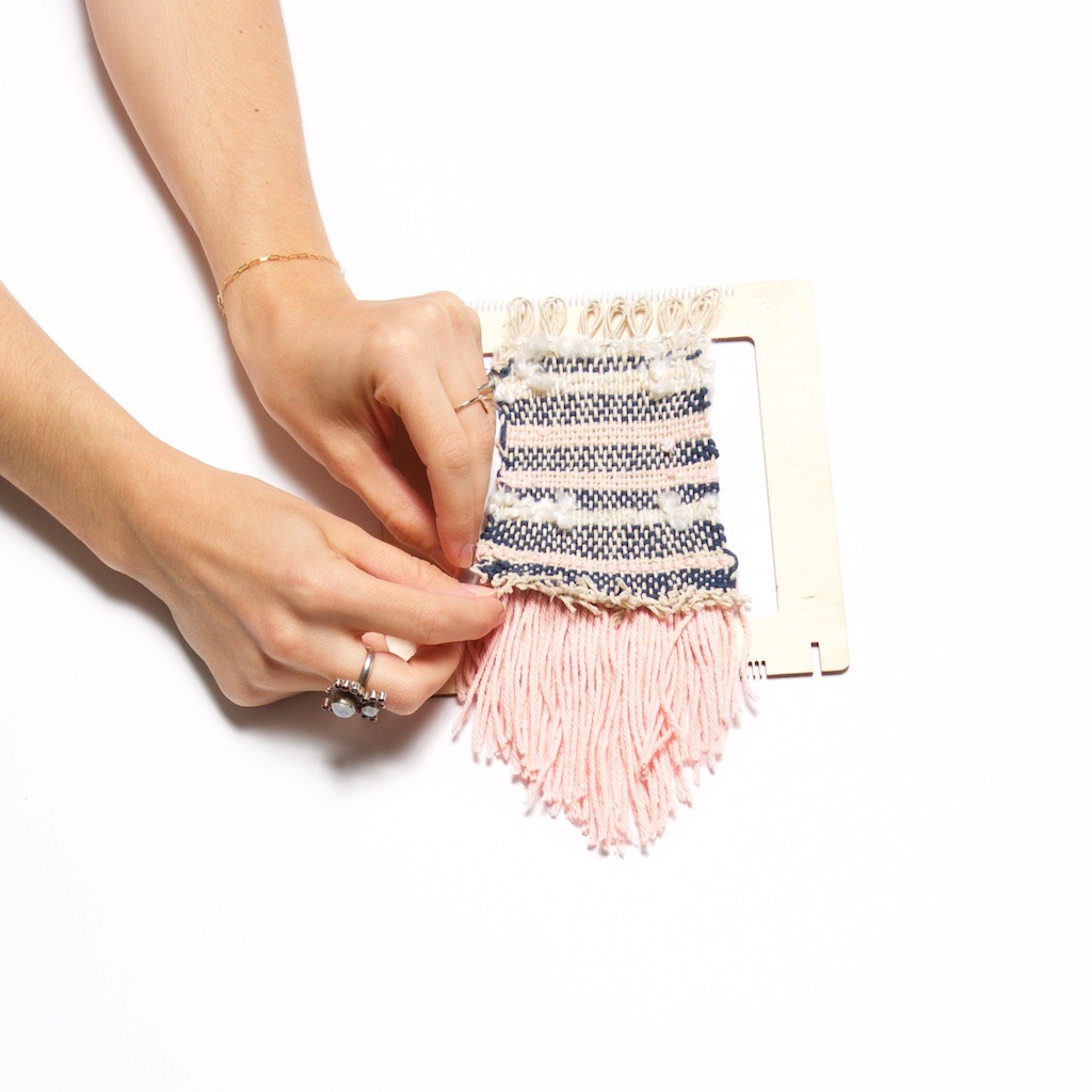 tuck the ends to finish a diy weaving wall hanging