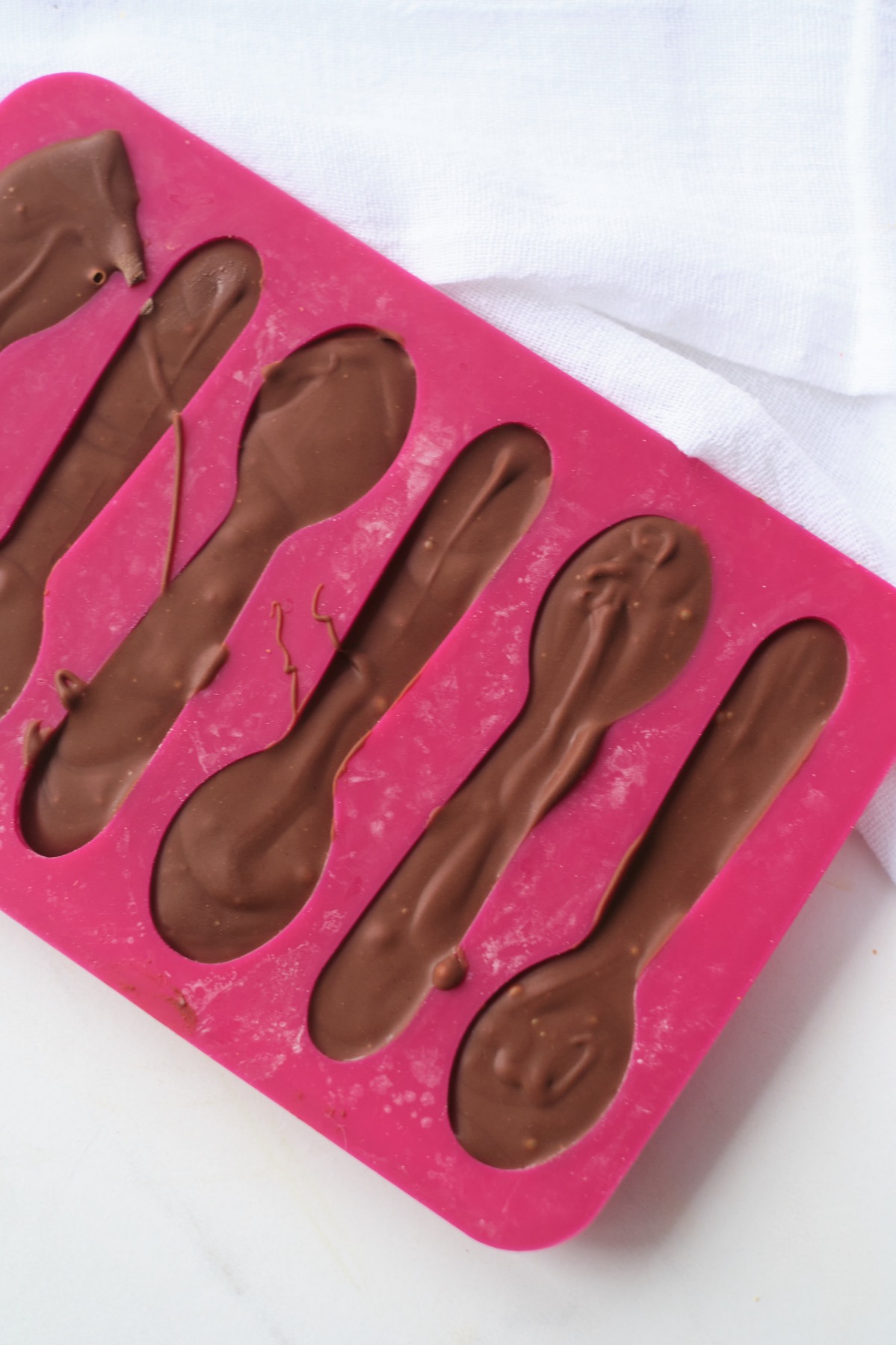 pour the chocolate in the spoon molds