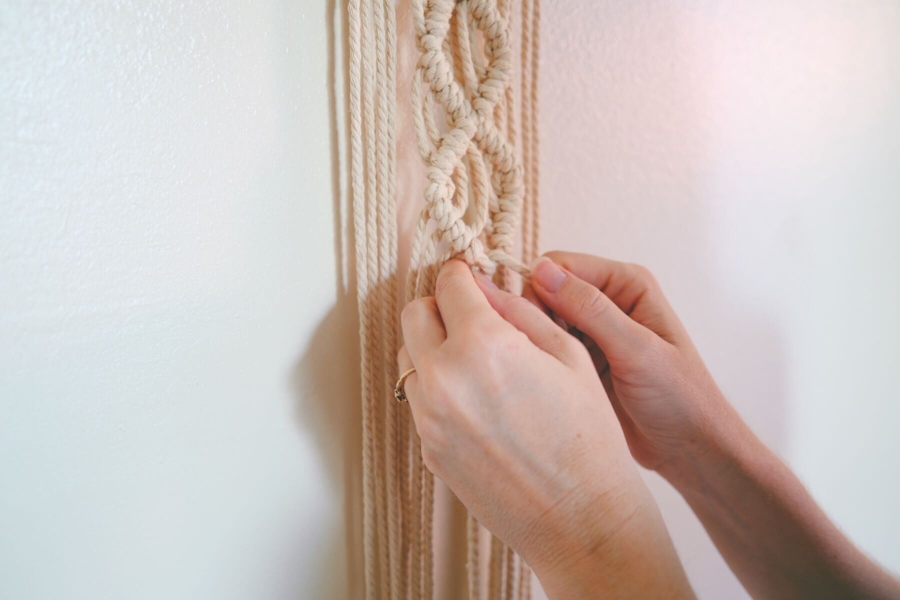 finishing the macrame knot work on the wall hanging