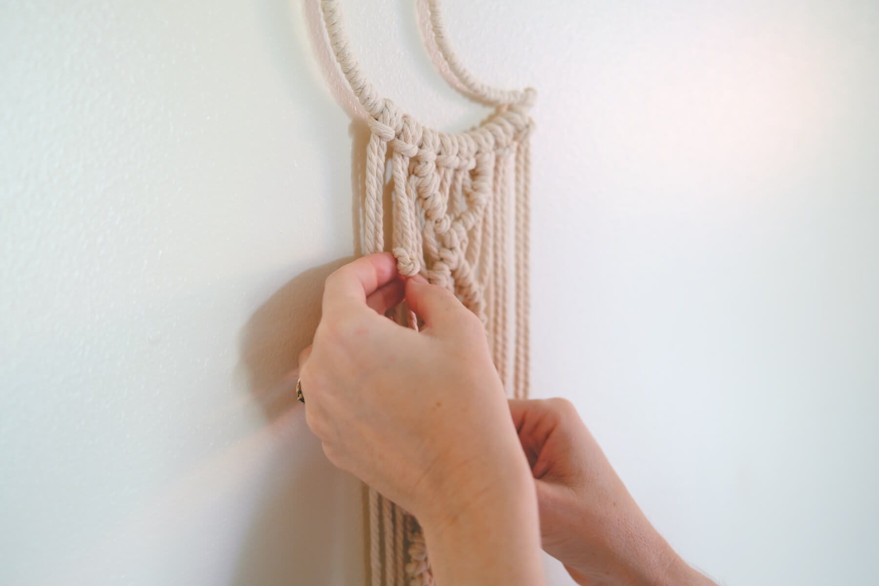 finishing the macrame knots on the wall hanging