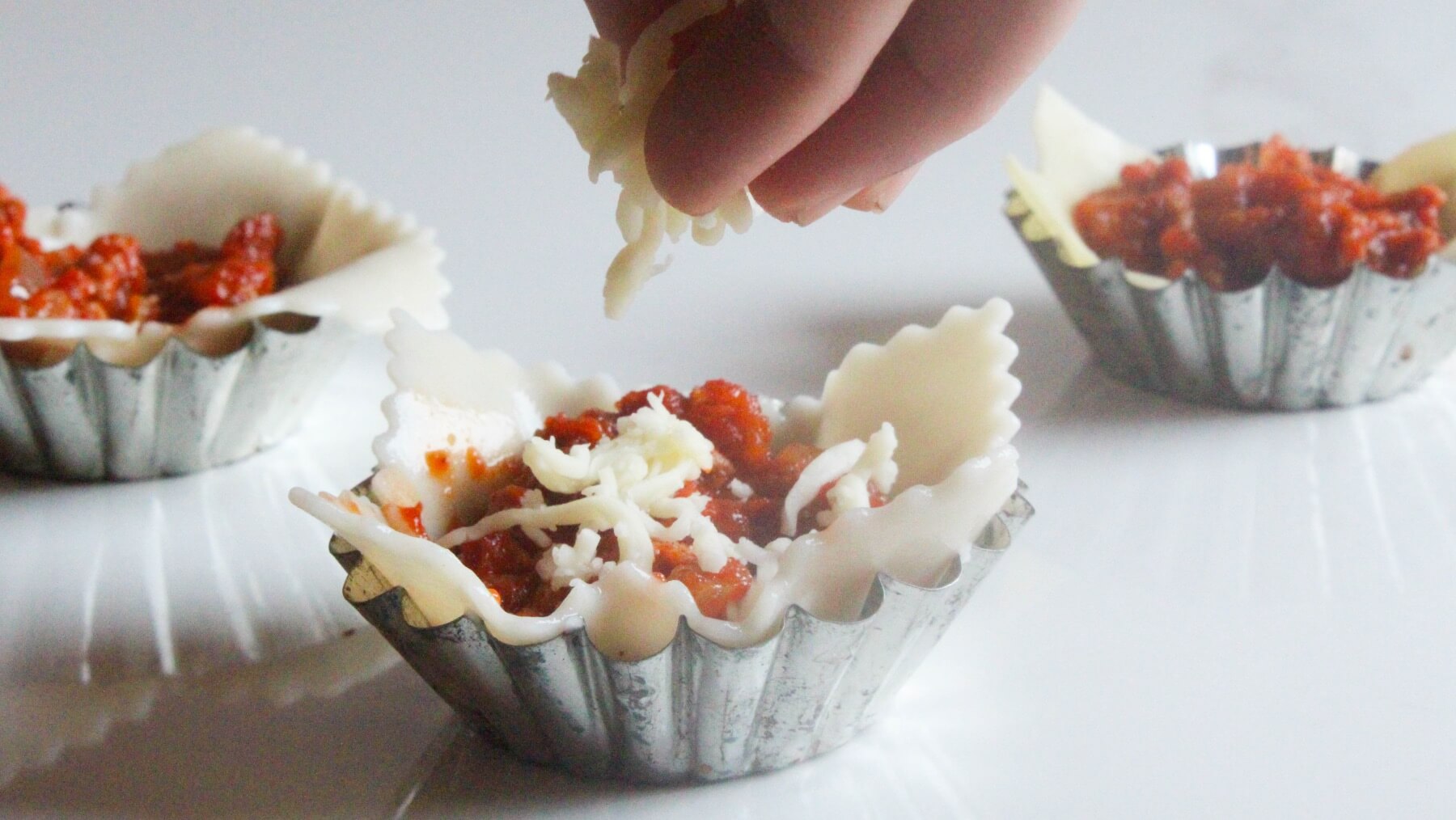 top the lasagne cups with cheese