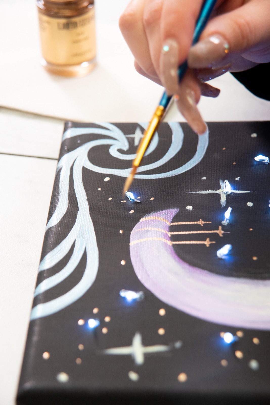 continue to add stars in gilding on the moon painting