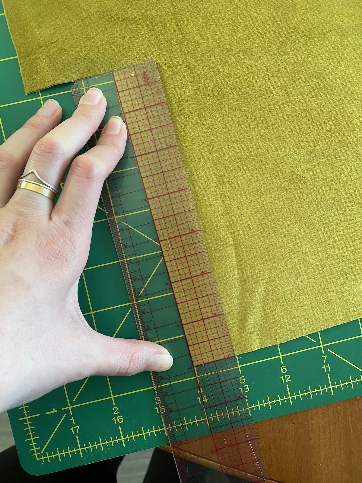 Photo of a piece of chartreuse velvet being cut with a quilting ruler