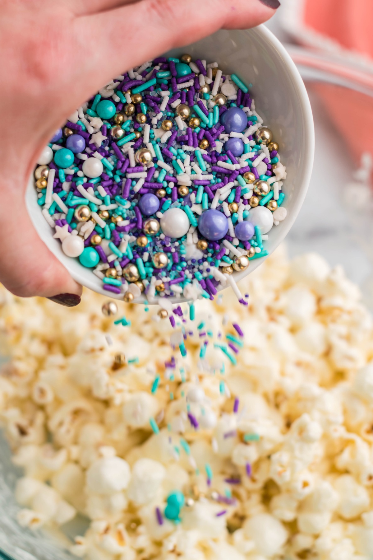 pour in sprinkles into the popcorn and chocolate